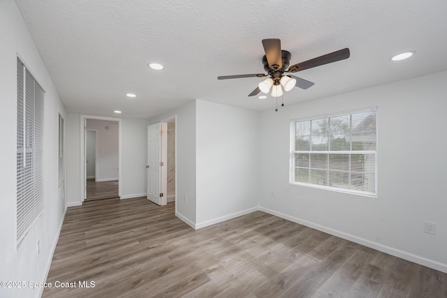 spare room featuring ceiling fan, light hardwood / wood-style floors, and a textured ceiling