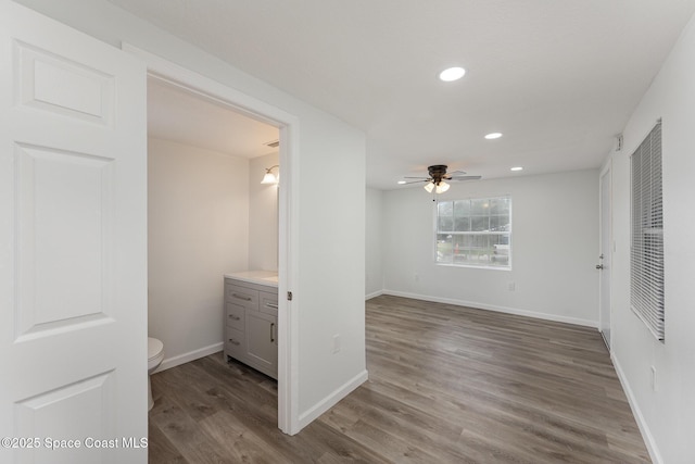 interior space featuring ensuite bath, ceiling fan, and hardwood / wood-style floors