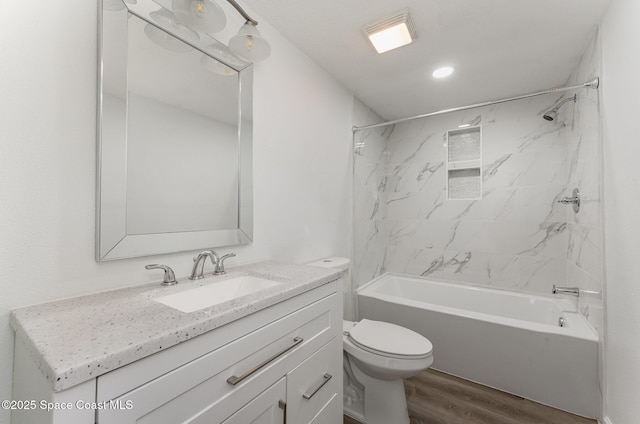 full bathroom with toilet, vanity, wood-type flooring, and tiled shower / bath