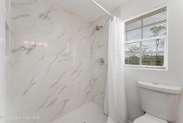 bathroom featuring toilet and curtained shower