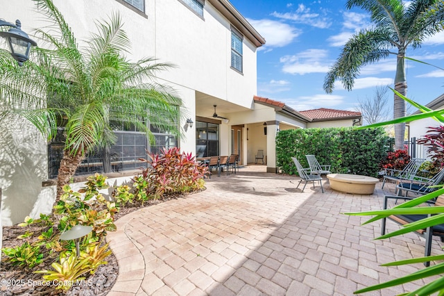 view of patio with ceiling fan and a fire pit