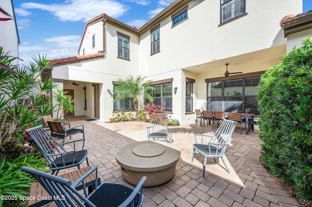 exterior space with a fire pit and ceiling fan