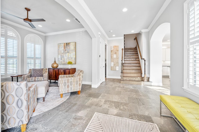 interior space with ceiling fan and crown molding