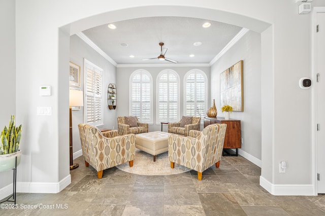 living area featuring ceiling fan and crown molding