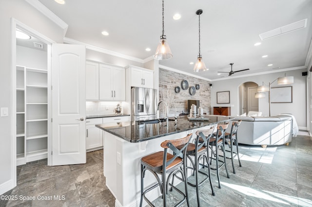 kitchen featuring white cabinets, a large island, a kitchen breakfast bar, and stainless steel fridge with ice dispenser