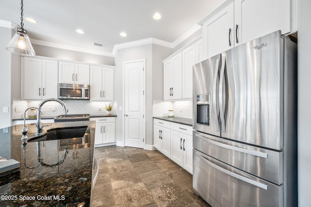 kitchen featuring dark stone counters, sink, hanging light fixtures, white cabinetry, and stainless steel appliances