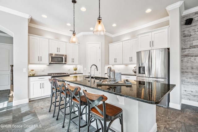 kitchen featuring appliances with stainless steel finishes, white cabinetry, a kitchen island with sink, and sink