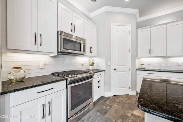 kitchen featuring white cabinets, stainless steel appliances, dark stone counters, and tasteful backsplash