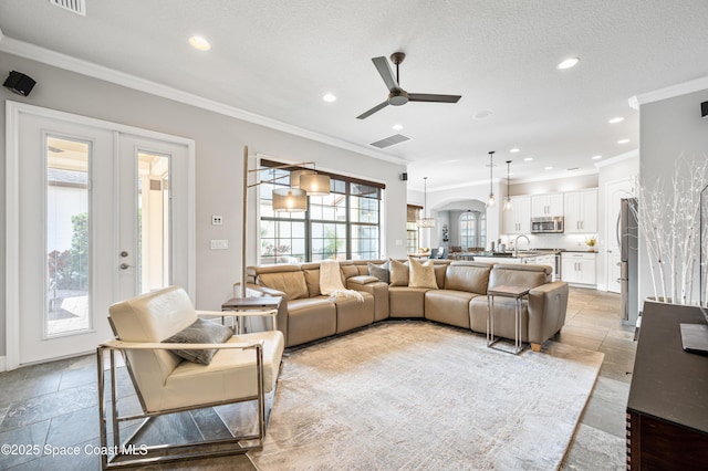 living room featuring french doors, ceiling fan, and crown molding