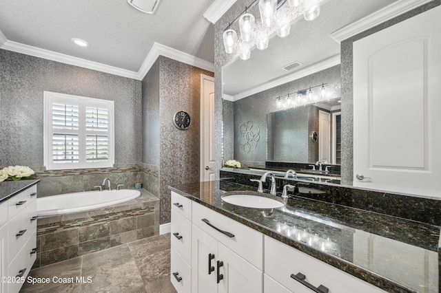 bathroom featuring tiled bath, vanity, a textured ceiling, and ornamental molding