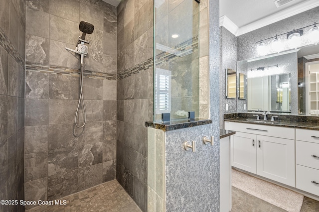 bathroom featuring a tile shower, vanity, and ornamental molding