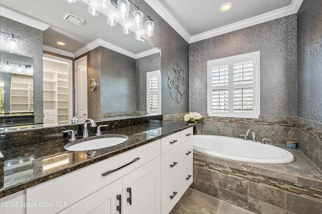 bathroom featuring vanity, ornamental molding, and tiled tub