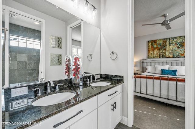 bathroom with ceiling fan, vanity, and a textured ceiling