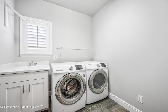 laundry room featuring separate washer and dryer, sink, and cabinets