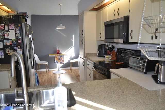 kitchen featuring pendant lighting, hardwood / wood-style floors, and stainless steel appliances