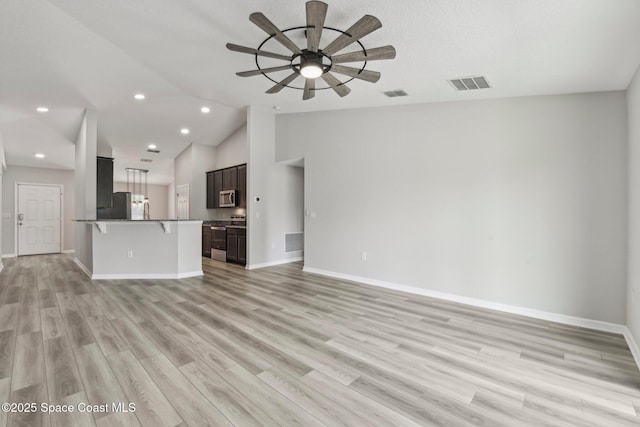 unfurnished living room with ceiling fan, light hardwood / wood-style floors, and vaulted ceiling