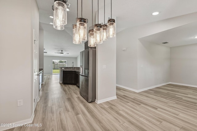 kitchen with hanging light fixtures, stainless steel fridge, light wood-type flooring, and ceiling fan