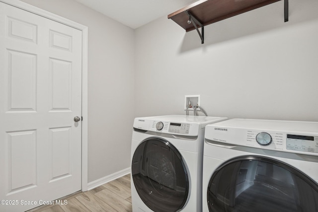 laundry room with washer and dryer and light hardwood / wood-style floors