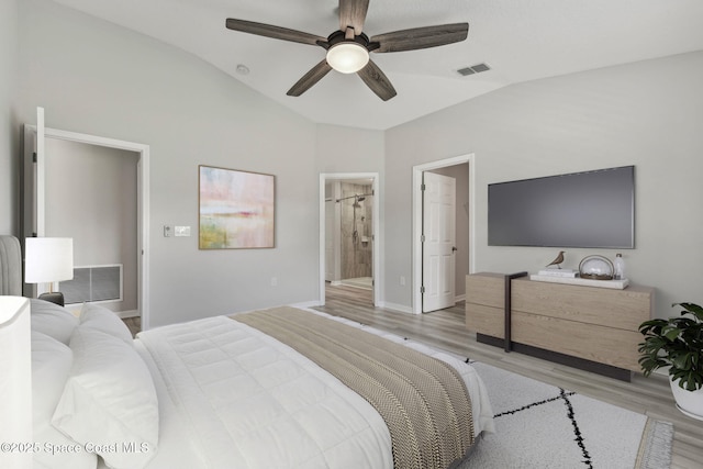 bedroom featuring ensuite bath, ceiling fan, lofted ceiling, and light wood-type flooring