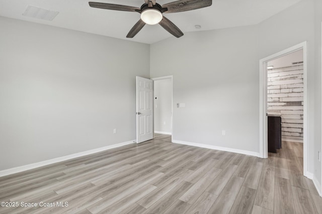 unfurnished room with ceiling fan, vaulted ceiling, and light hardwood / wood-style flooring