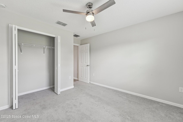 unfurnished bedroom featuring ceiling fan, a closet, and light carpet