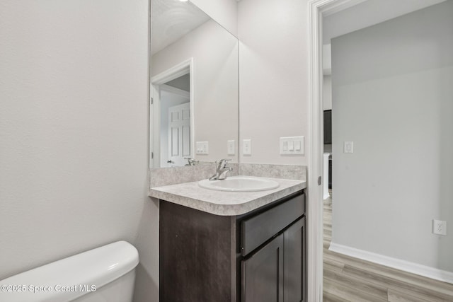 bathroom with vanity, hardwood / wood-style flooring, and toilet