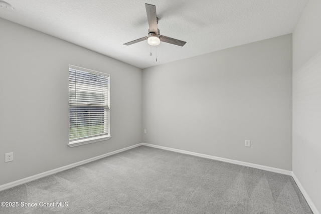 carpeted spare room with a textured ceiling and ceiling fan