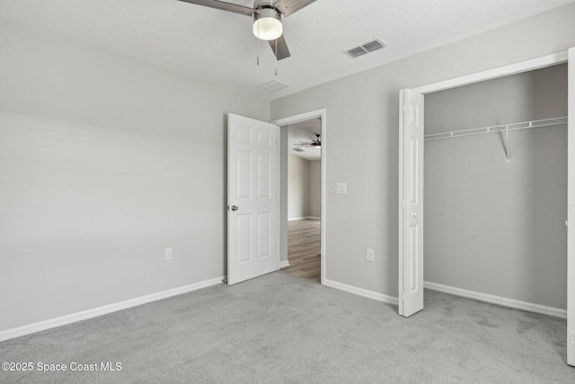 unfurnished bedroom with ceiling fan, a closet, and light carpet