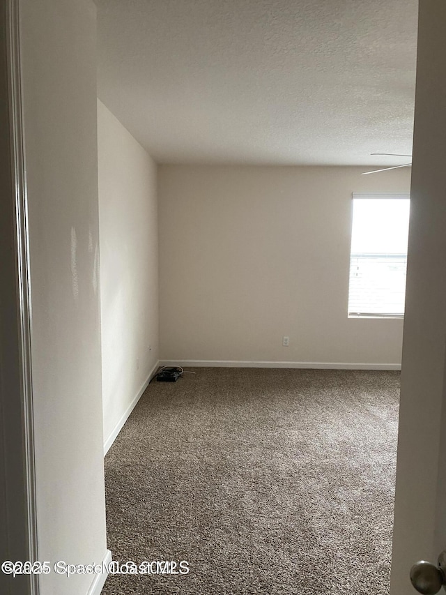 unfurnished room featuring carpet flooring and a textured ceiling