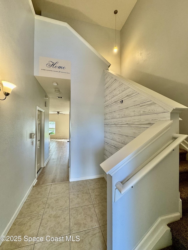 hallway with tile patterned floors and vaulted ceiling