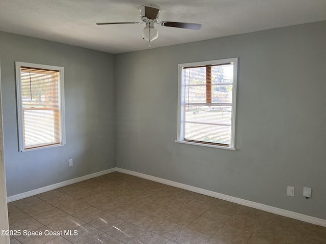 tiled spare room with ceiling fan and plenty of natural light