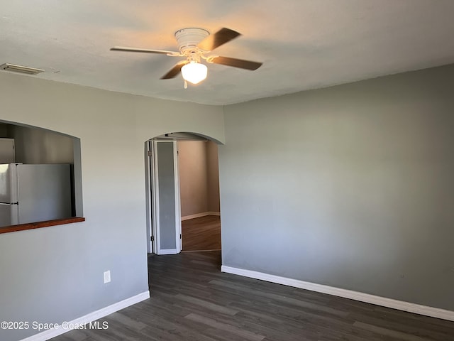 spare room with ceiling fan and dark wood-type flooring