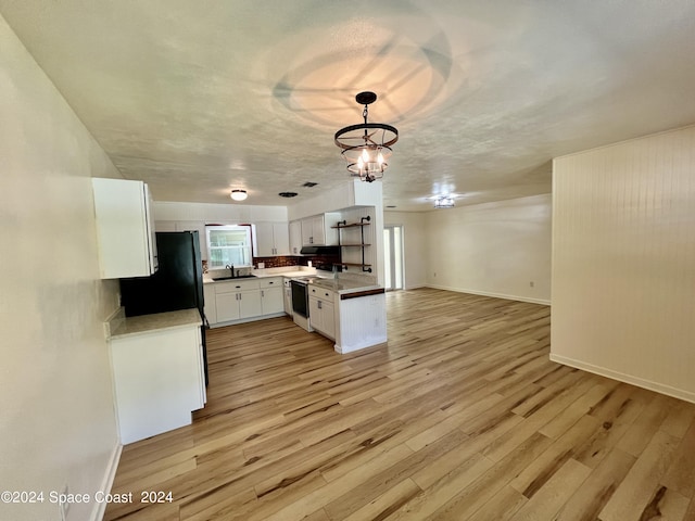 kitchen with sink, electric range, white cabinets, light hardwood / wood-style floors, and hanging light fixtures