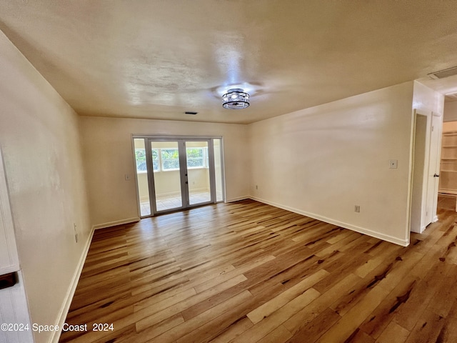 spare room with french doors and hardwood / wood-style floors