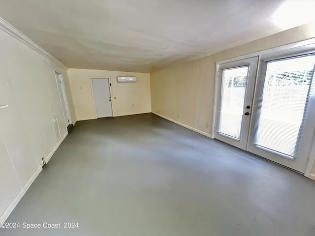 unfurnished room featuring french doors and an AC wall unit