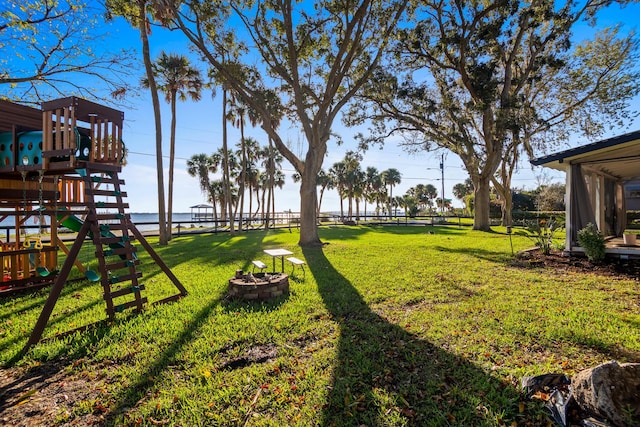 view of yard with a fire pit and a playground