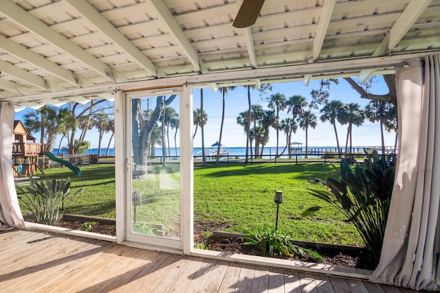 unfurnished sunroom with a water view, plenty of natural light, and ceiling fan