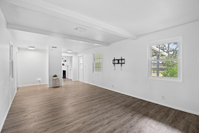 unfurnished living room with beamed ceiling, wood-type flooring, and a brick fireplace