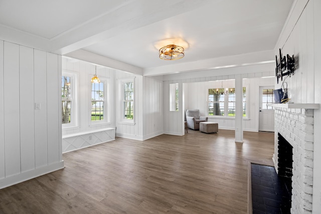 unfurnished living room featuring a fireplace, a healthy amount of sunlight, and dark hardwood / wood-style floors