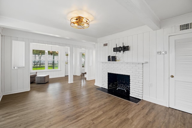 unfurnished living room with beamed ceiling, hardwood / wood-style floors, a fireplace, and ornamental molding