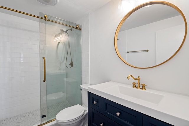 bathroom featuring vanity, toilet, and a shower with shower door