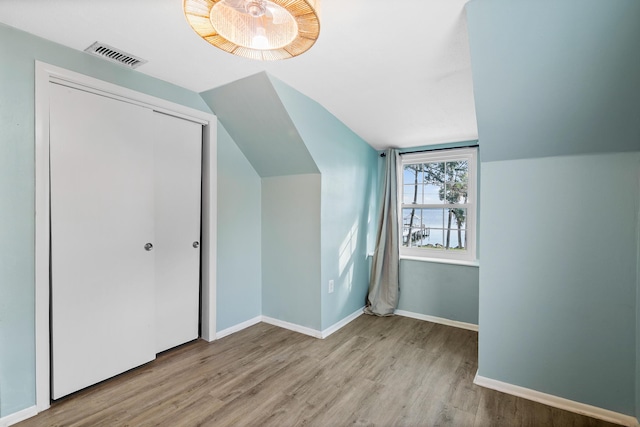 bonus room featuring lofted ceiling and light wood-type flooring