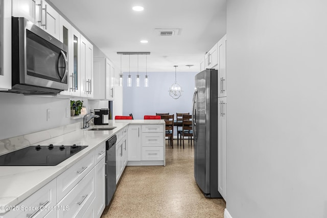 kitchen with kitchen peninsula, appliances with stainless steel finishes, white cabinetry, and sink