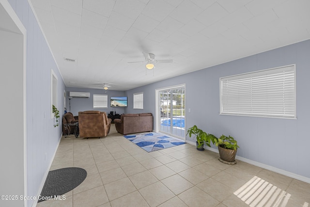 living room with a wall mounted AC, ceiling fan, light tile patterned floors, and wood walls