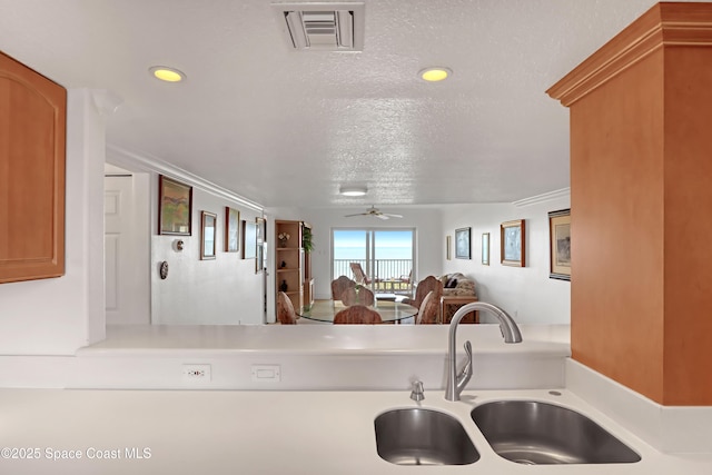 kitchen with ceiling fan, sink, and a textured ceiling