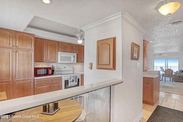 kitchen featuring ceiling fan, crown molding, a textured ceiling, white appliances, and light tile patterned flooring