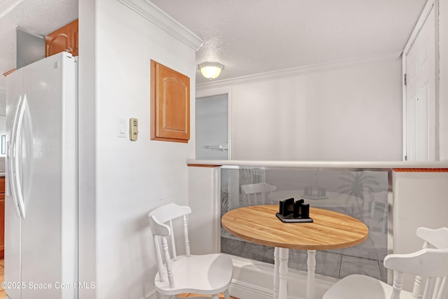 dining area featuring a textured ceiling and ornamental molding