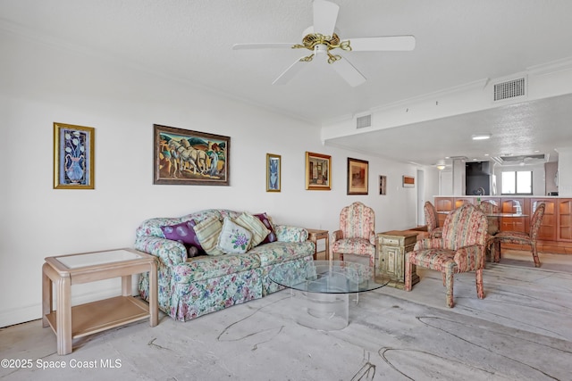 living room featuring a textured ceiling, ceiling fan, and ornamental molding