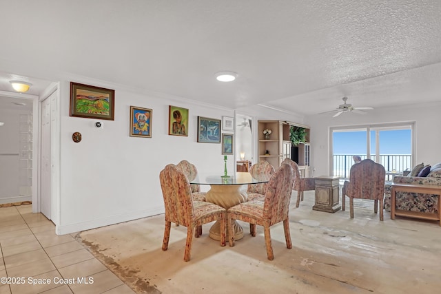 tiled dining space featuring a textured ceiling and ceiling fan