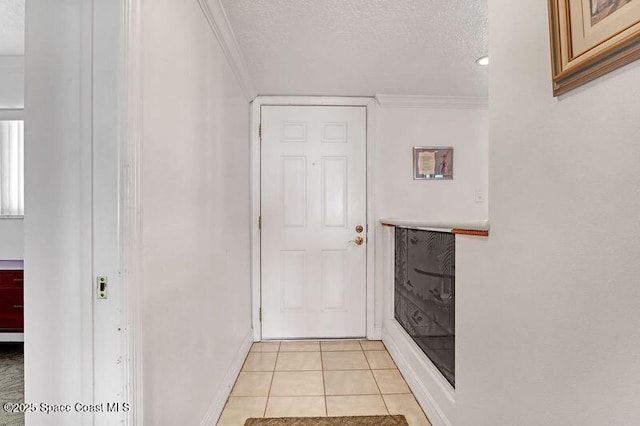 corridor with a textured ceiling, crown molding, and light tile patterned flooring